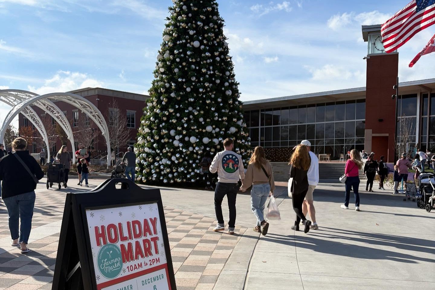 people walking outside near a 40 foot tall christmas tree